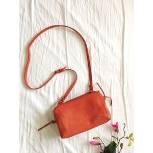 The twin-pouch crossbody in burnt orange